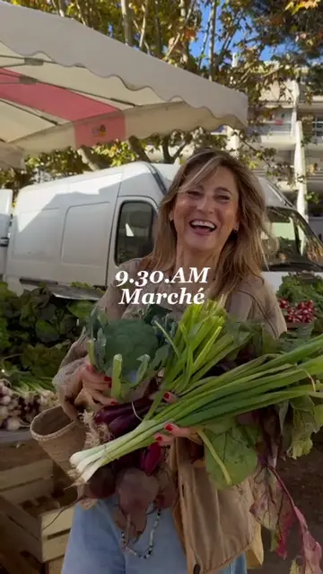 Cliente souriante au marché, bras chargés de légumes, pour L'Atelier Nutrition
