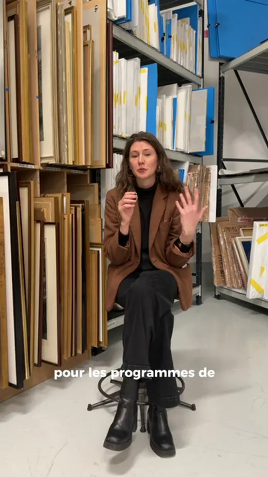 Interview assise dans les réserves d'œuvres d'art, entre des rayonnages de tableaux