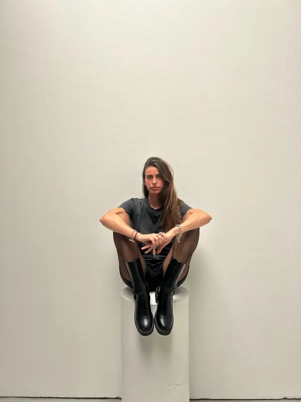 Portrait de Julie Fournier assise sur un socle blanc